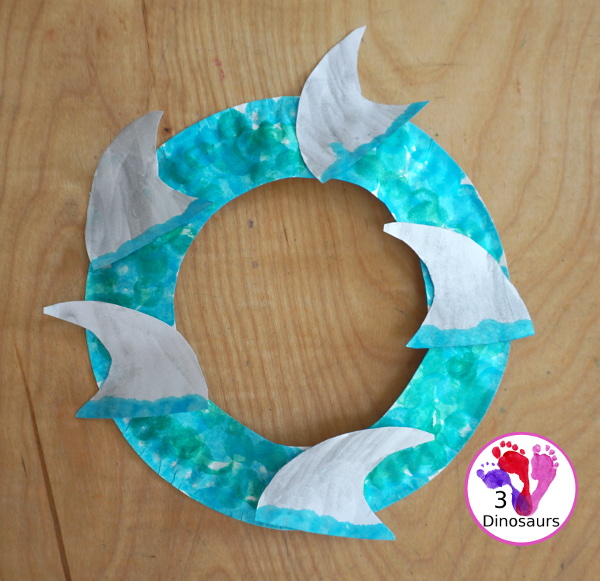 Shark Fin Wreath Craft for Shark Week - that kids can make with a shark cookie cutter and a paper plate. A super easy wreath for all ages.- 3Dinosaurs.com